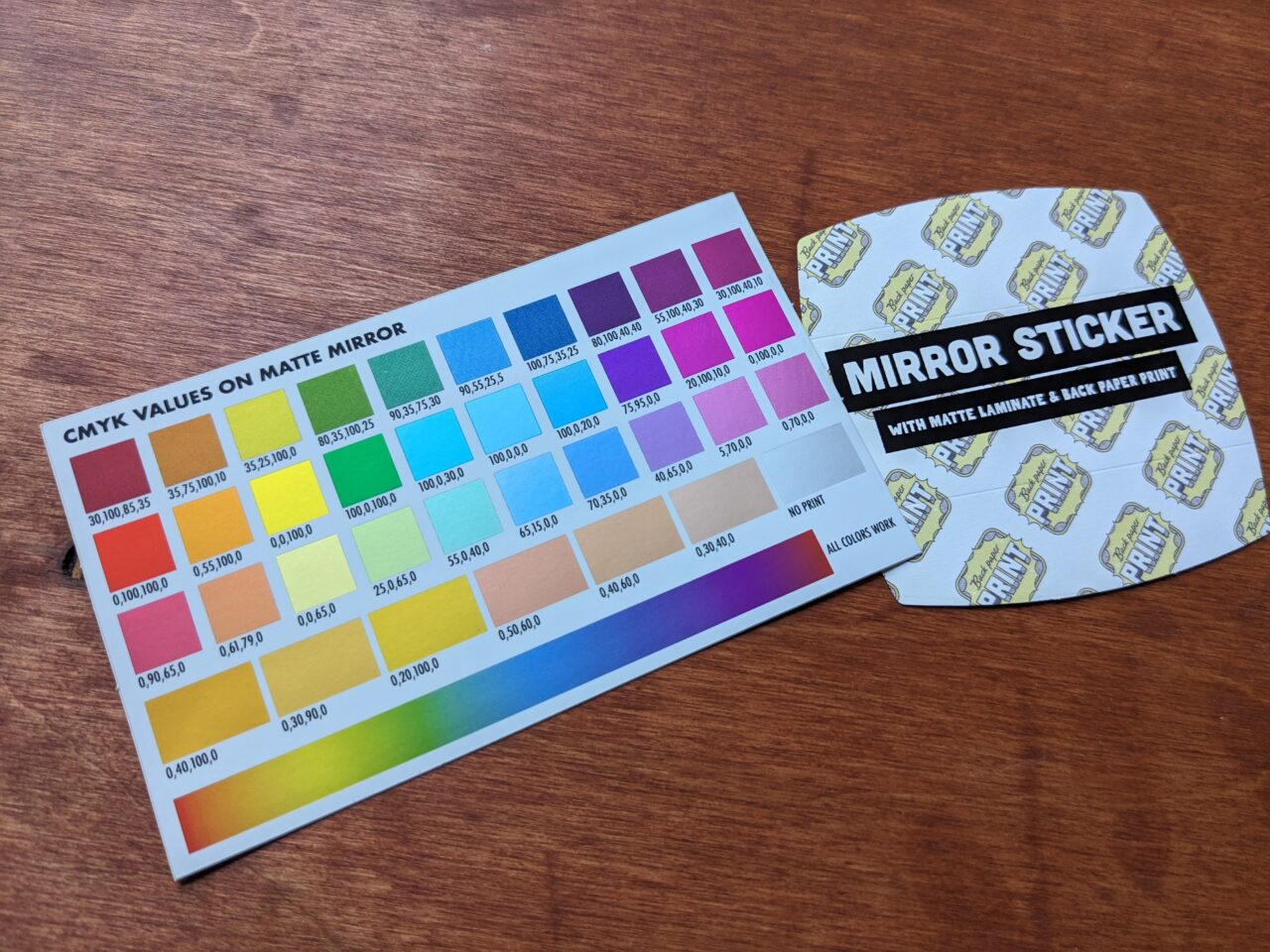 The color card and back of the matte mirror-printed stickers. The back of the sticker has a repeating motif that says Back Printing, and a label identifying the print stock.