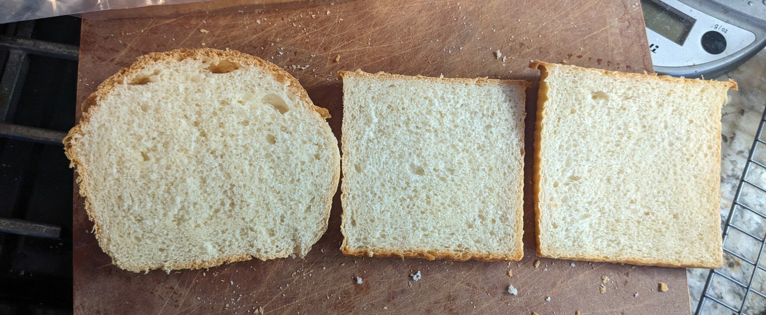 Three slices of white bread. The one on the right has a round top, and the center and left loaves are square.